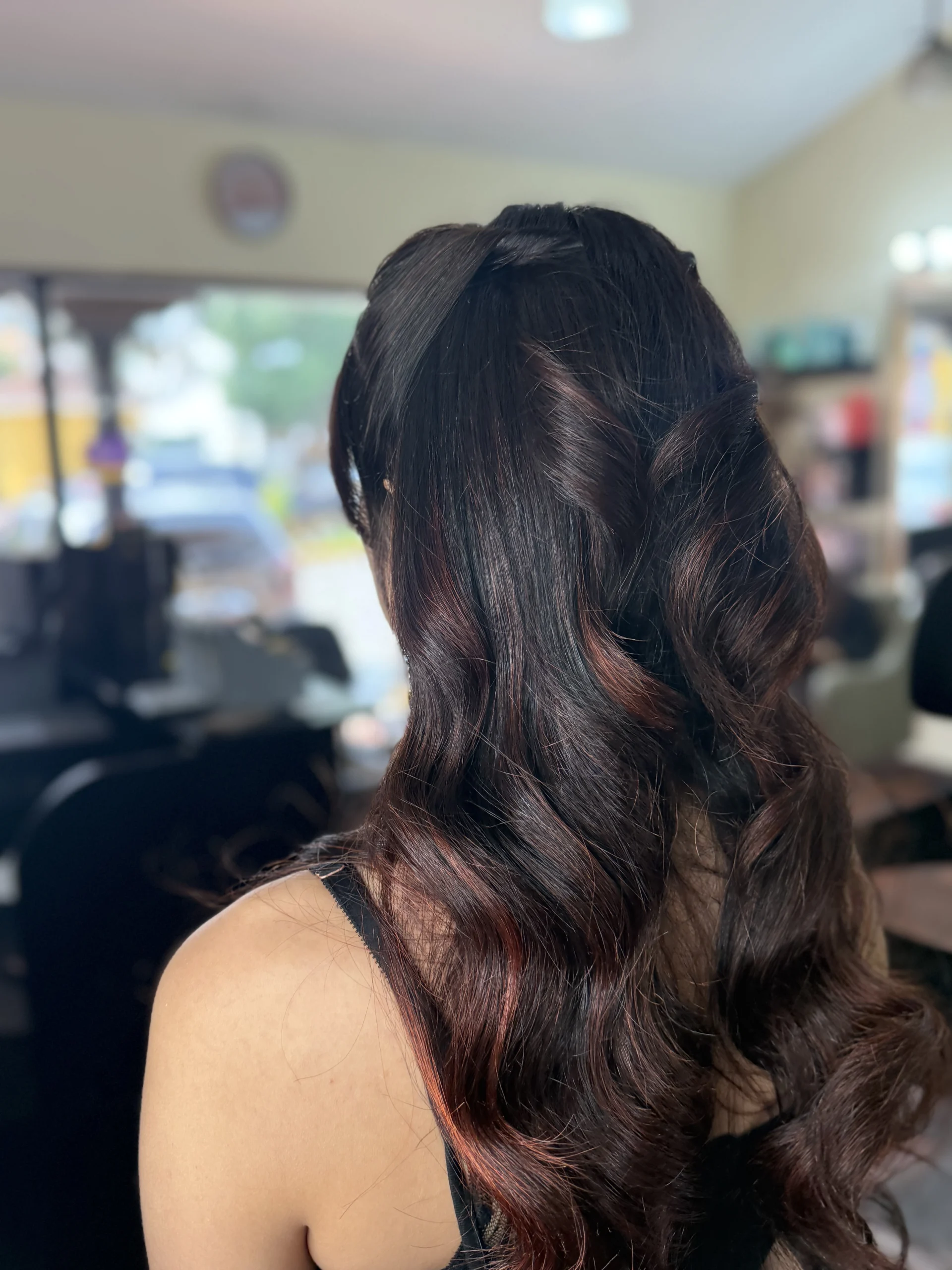 Cabello ondulado con reflejos cobrizos como resultado de un tratamiento capilar en Moon Salon
